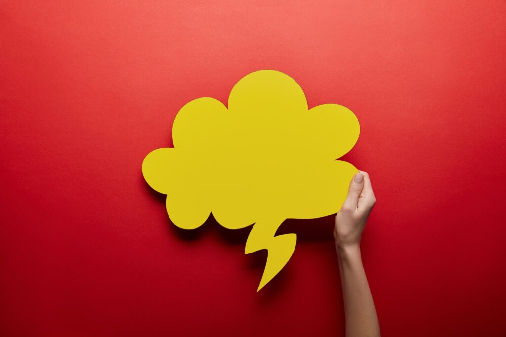 top view of empty yellow thought bubble on red background