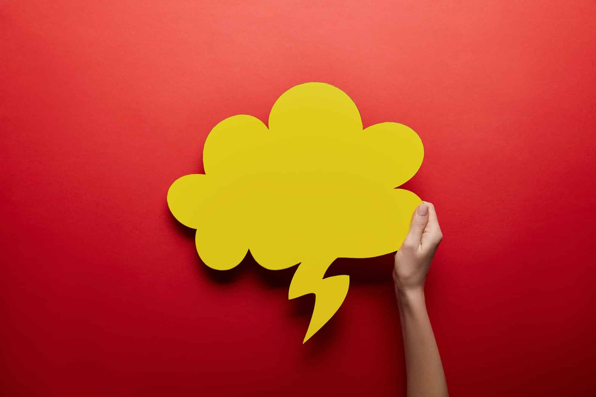 top view of empty yellow thought bubble on red background
