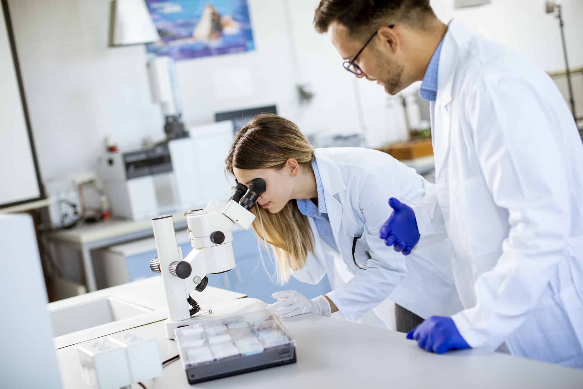 Group of young researchers analyzing chemical data in the laboratory